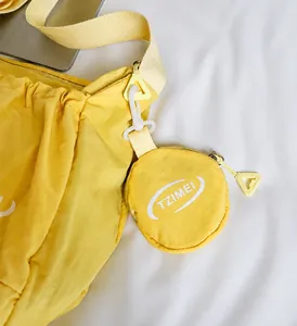 Détail de la mini pochette ronde amovible avec logo TZIMEI sur sac en nylon