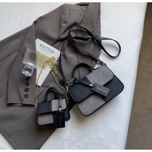 Flat lay of small and large color-block handbags with leather and chain straps
