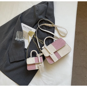 Detail of pink and beige two-tone knit handbags with chain straps and fashion tags