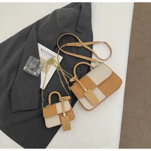 Two-piece set of checkered woven handbags including a mini charm bag on grey blazer