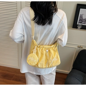 Detail of yellow nylon crossbody bag with drawstring closure and matching round coin purse