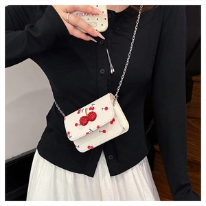 Sac bandoulière blanc tendance avec motifs cerises et bandoulière chaîne chic
