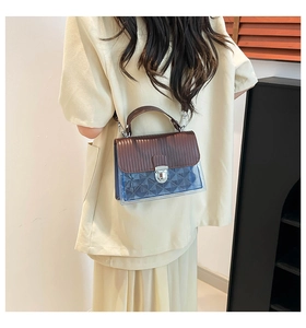 Dettaglio in pelle marrone e materiale jelly blu trasparente su una borsa a tracolla