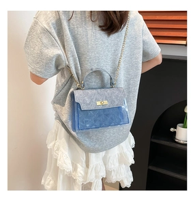 Blue transparent PVC crossbody bag with gold chain strap shown on model from behind