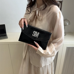 Slim black envelope clutch bag with rhinestone letter decor and glossy finish