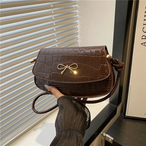 Dark brown crocodile embossed crossbody bag with golden bow and knotted shoulder strap