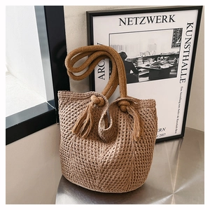 Detail of hand-woven tote bag with thick rope handles and fringe decorative knots
