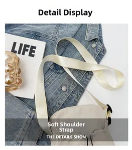 Detail of the soft fabric wide shoulder strap and drawstring closure on the crossbody bag
