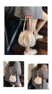 Close-up of floral drawstring shoulder bag with detailed texture and crossbody strap style
