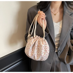 Floral drawstring bucket bag with red flower pattern and thin shoulder strap