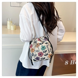 Detail of vintage floral jacquard bucket bag with drawstring closure and shoulder strap