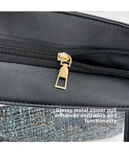 Macro detail of smooth golden geometric metal zipper pull on premium black leather tote