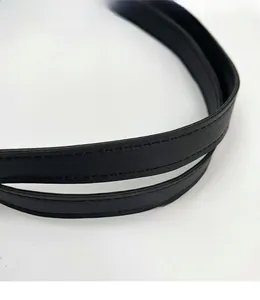 Macro shot of black leather handbag strap with durable double stitching and smooth finish