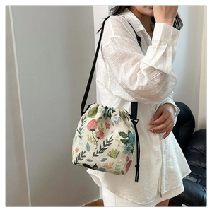 Detail of floral strawberry pattern on vintage beige drawstring bucket shoulder bag
