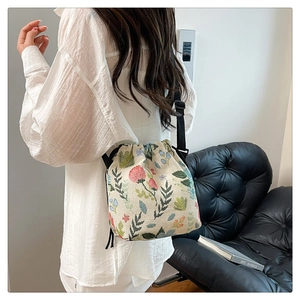 Detail of floral jacquard bucket bag with drawstring closure and adjustable shoulder strap