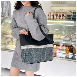 Detailed view of tweed and black PU leather patchwork tote bag with lace trim