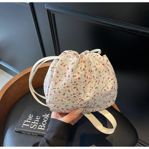 Top view of floral drawstring bucket bag with leather strap and book prop