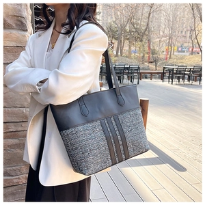 Close-up of black leather and grey tweed patchwork design on a large tote bag