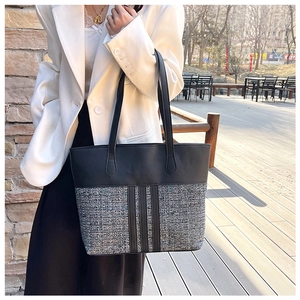 Close-up of a large PU tote bag featuring black leather and tweed patchwork design