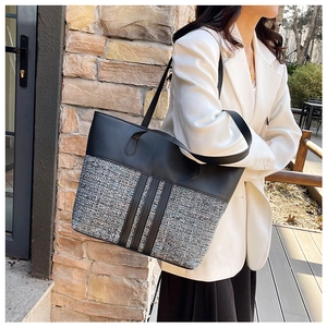Detail of minimalist tote bag showing mixed leather and woven fabric texture on model