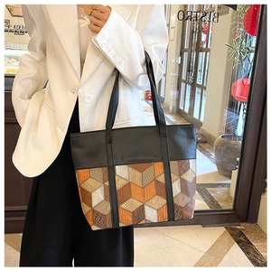 Detail of PU leather tote bag featuring geometric color block patchwork and snakeskin texture