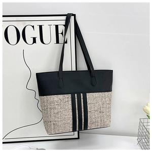 Detail of minimalist contrast stitching tote bag with beige tweed and black PU leather