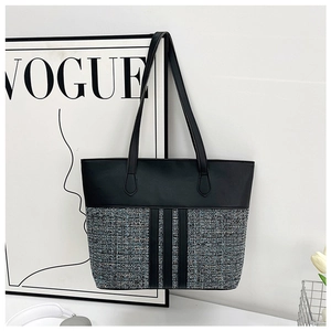 Detail view of large patchwork tote bag featuring grey tweed and premium black PU leather