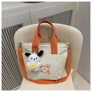Detail of canvas tote bag with contrast orange handles and cute cartoon bear print