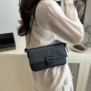 Chic black litchi pattern leather baguette bag styled as a minimalist shoulder underarm bag
