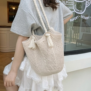 Off-white hand-woven hollow knit tote bag with thick rope handles and tassel details
