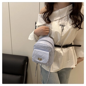 Detail of light purple quilted backpack featuring chain straps and metal twist lock