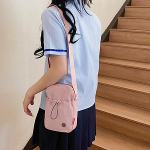 Pink nylon sports crossbody bag with adjustable strap and front zipper pocket