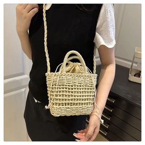 Detail of hand-woven straw crossbody bag with secure drawstring inner pouch and strap