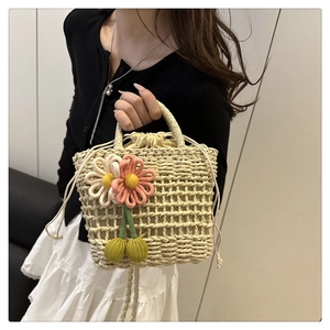 Detail of straw woven bag with crochet floral accents and drawstring fabric liner