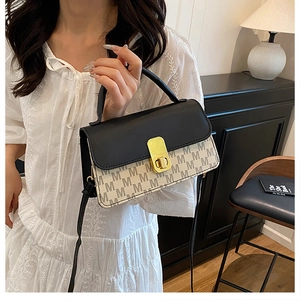 Detail of crossbody bag with M-letter jacquard pattern and golden metallic twist lock