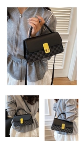 Close-up of stylish black crossbody bag with M-pattern print and gold rectangular lock