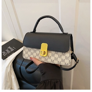 Close-up of contrast crossbody bag with M-letter print and golden metallic twist lock