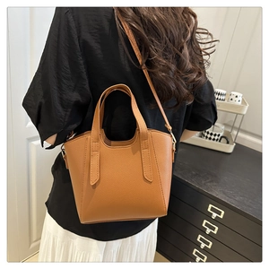 Detail of caramel lychee grain leather tote bag showing texture and adjustable strap