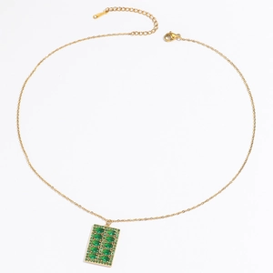 Détail d'un collier en titane doré avec un pendentif rectangulaire en zircon émeraude
