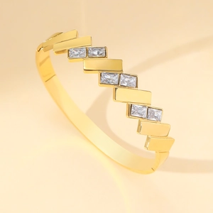 Minimalist gold plated stainless steel bangle featuring geometric tiers and zircon stones