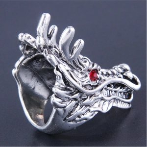 Dettaglio macro di un anello a testa di drago vintage con incisioni e occhio di cristallo