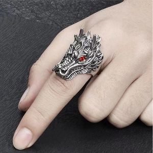 Dettaglio dell'anello a testa di drago vintage con squame e occhi di pietra rossa