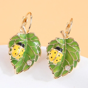 Élégantes boucles d'oreilles coccinelle et feuille verte dorées avec détails cristaux
