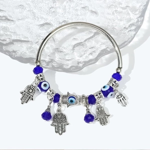 Elegant Hamsa Hand and Evil Eye beaded bracelet with blue crystals on water surface