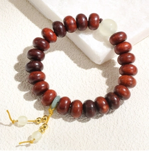 Vue détaillée du bracelet en perles de bois brun avec perle translucide et nœud tressé