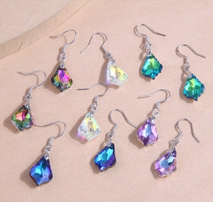 Detailed view of colorful teardrop crystal earrings in silver metal setting hooks