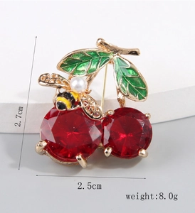 Detail of red cherry brooch with gold bee and dimensions 2.7cm by 2.5cm