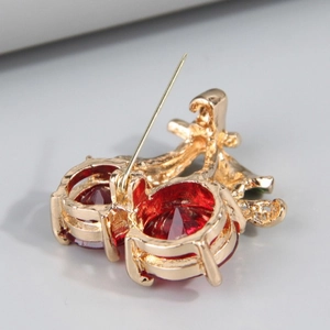 Sweet cherry brooch with red crystals and gold-plated metal base shown from back