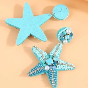 Bohemian style starfish earrings with blue beads and crystals on an orange background