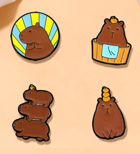 Détails de quatre pins en émail de capybara avec des poses amusantes et polies